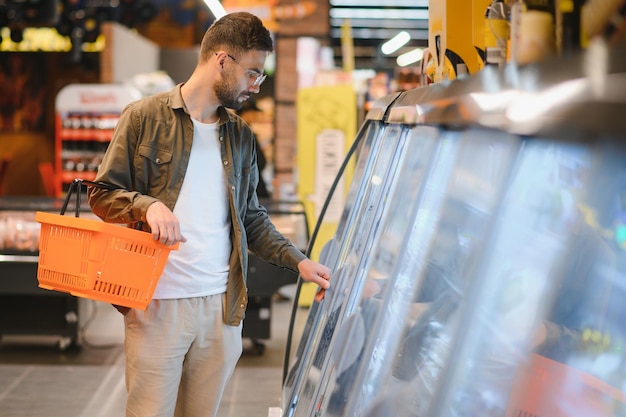 Ein hübscher Mann, der im Supermarkt einkaufen geht