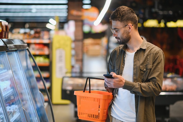 Ein hübscher Mann, der im Supermarkt einkaufen geht