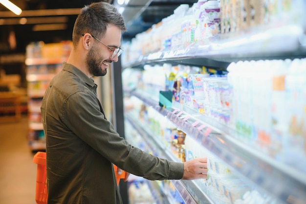 Ein hübscher Mann, der im Supermarkt einkaufen geht