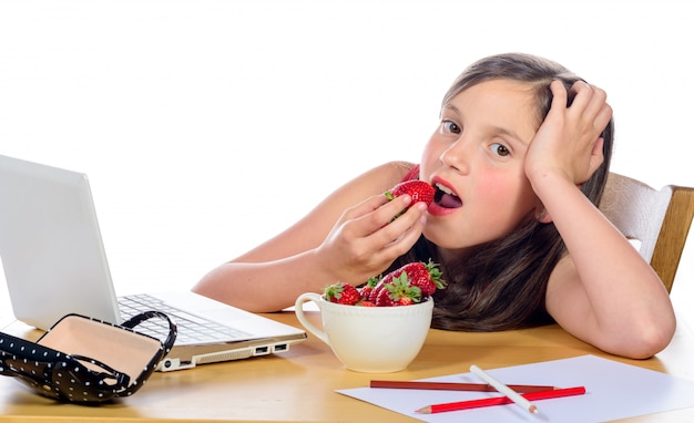 Ein hübsches kleines Mädchen isst Erdbeeren