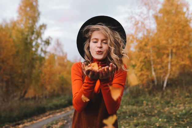 Foto ein hübsches mädchen genießt die einsamkeit, trinkt kaffee, spaziert im herbst im wald, in der natur im herbst.