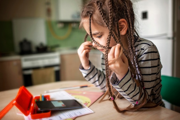 Ein hübsches, stilvolles Schulmädchen studiert Mathematik während ihres Online-Unterrichts zu Hause Online-Bildungskonzept