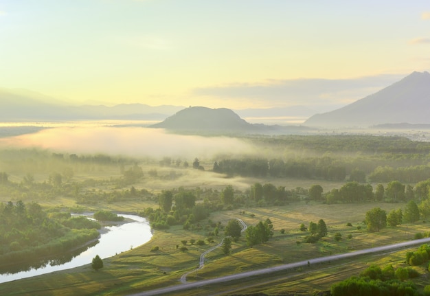 Ein Hügel im Nebel im Tal des Katun-Flusses unter einem goldenen Himmel im Altai-Gebirge. Sibirien, Russland