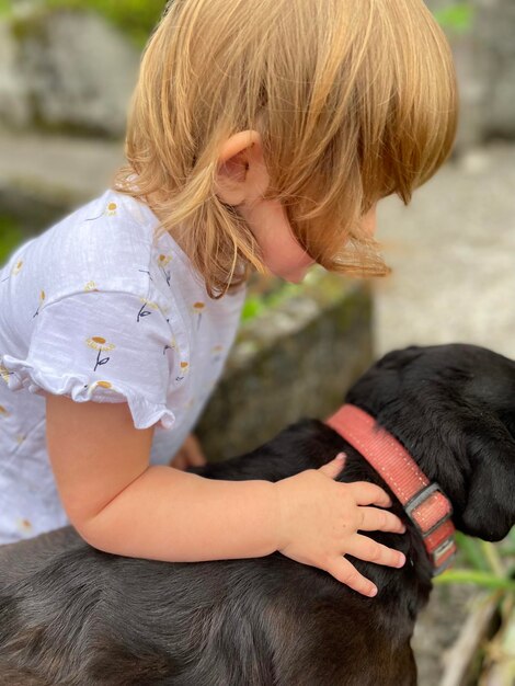 Foto ein hund, der ein kind streichelt