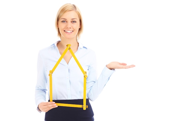 Ein Immobilienmakler, der gelbes Maß zeigt und auf weißen Hintergrund zeigt