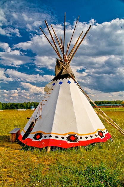 Ein indisches Tipi, das auf einer Wiese inmitten von Pinienwäldern im Hochformat aufgestellt ist