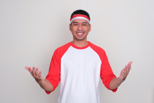 Ein indonesischer Mann lächelt mit offenen Händen und grüßt herzlich