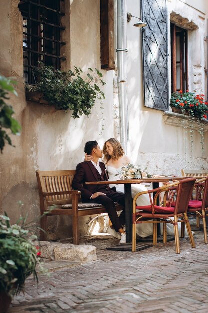 Ein internationales Hochzeitspaar, eine europäische Braut und ein asiatischer Bräutigam spazieren gemeinsam durch die Stadt