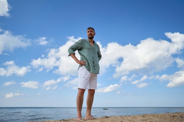 Ein jahrelanger kaukasischer Mann steht vor dem Ostsee in Lettland.