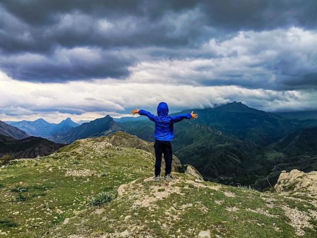 Ein Junge auf dem Hintergrund einer atemberaubenden Aussicht auf die Berge während eines Gewitters in Dagestan Kaukasus Russland