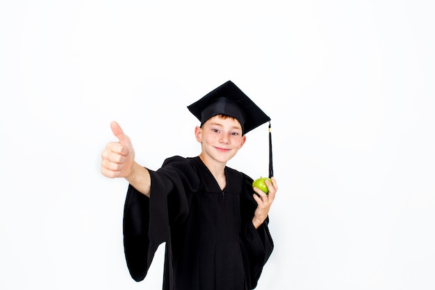 Ein Junge in einem Studentenhut mit einem Apfel in der Hand