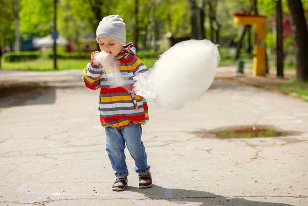 Ein Junge in einem Vergnügungspark isst Zuckerwatte