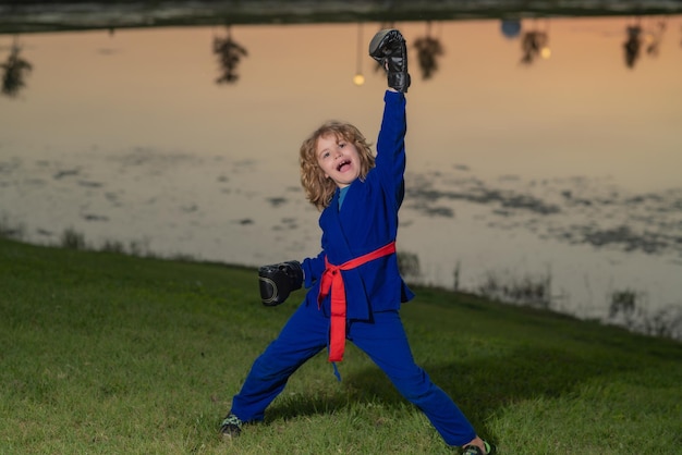 Ein Junge in Kimono übt Judo, Taekwondo, Jujitsu, Kungfu, Jiu-Jitsu, Aikido, Outdoor-Sport und Karate für Kinder.