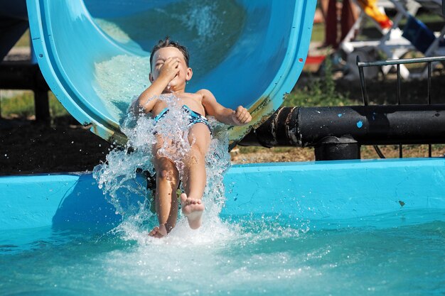 Foto ein junge in voller länge fährt in einem schwimmbad im wasserpark.