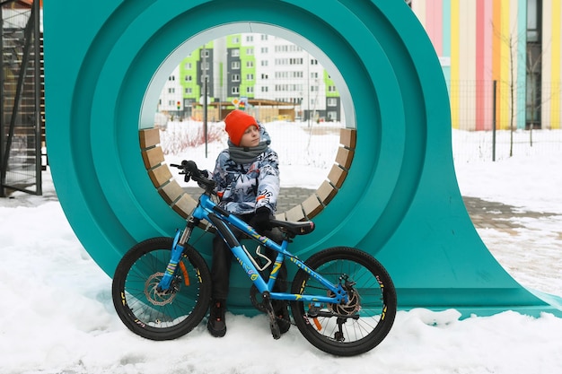 Ein Junge in Winterkleidung machte eine Pause beim Fahrradfahren