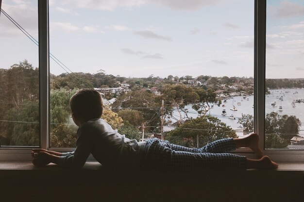 Foto ein junge liegt zu hause am fenster