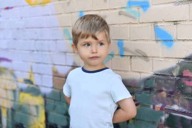 Ein Junge mit blauen Augen in der Nähe einer bunten Wand