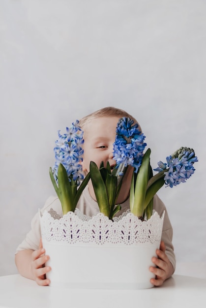 ein junge mit blumen das kind kümmert sich um die blumen blaue hyazinthe