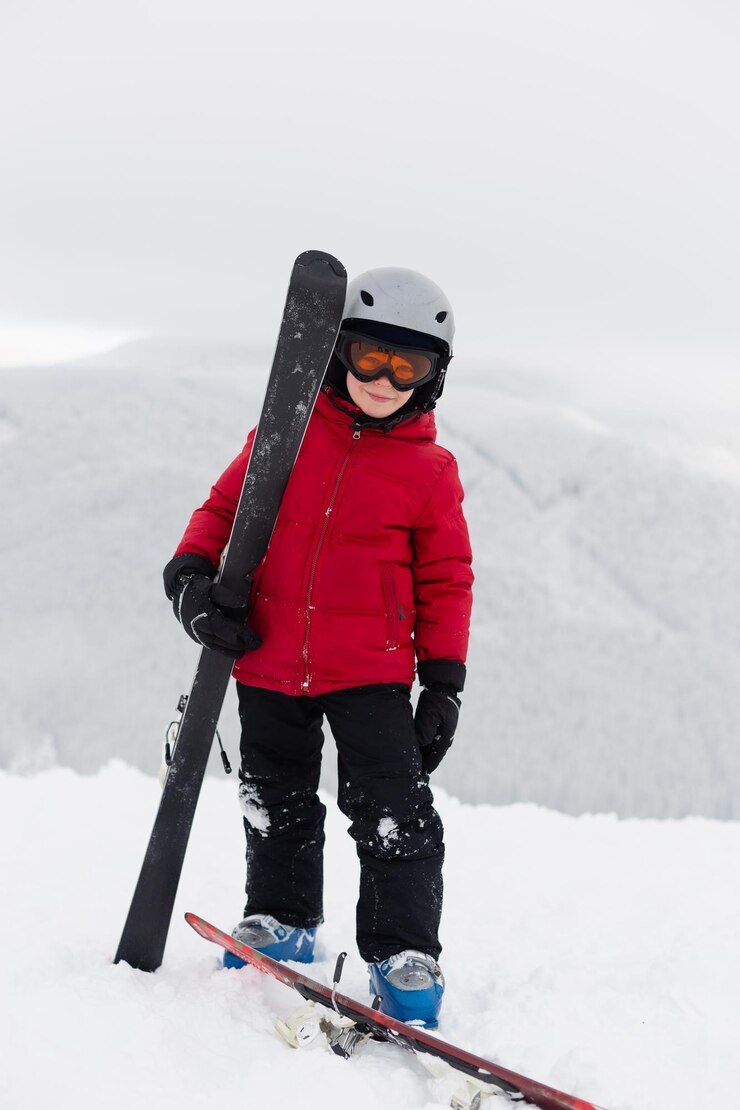 Ein Junge mit Brille und Helm vor dem Hintergrund der Berge.