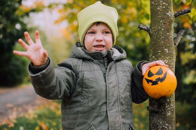 Ein Junge mit einem Halloween-Kürbis mit Augen Das Fest der Angst Halloween