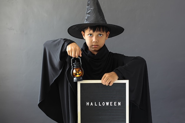 Ein Junge mit Halloween-Kostüm und hält eine Laterne