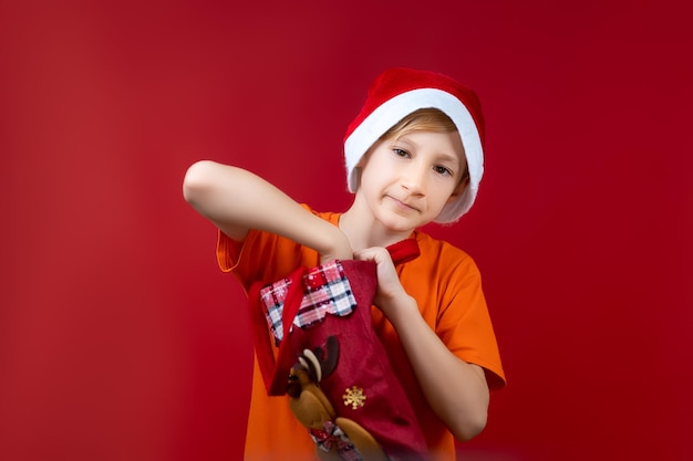 Ein Junge mit Weihnachtsmütze steckte seine Hand in eine Weihnachtstüte