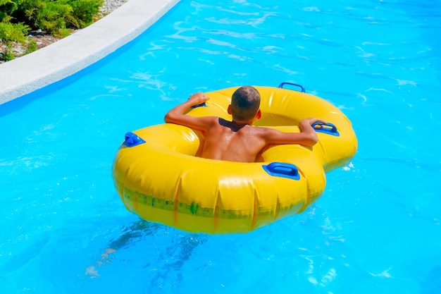 Ein junge schwimmt auf einem aufblasbaren ring im pool des wasserparks