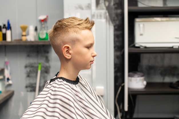 Ein Junge sitzt in einem Friseursalon und lässt sich die Haare machen