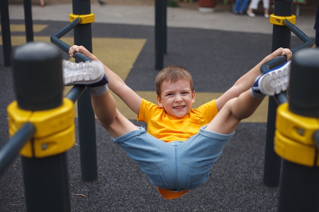 Ein Junge spielt im Sommer draußen auf dem Spielplatz. Sport. Freizeit für Kinder.