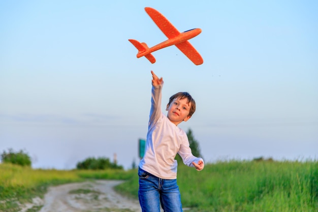 Ein Junge spielt im Sommer in einem Flugzeug in der Natur Der Junge träumt von der Zukunft Kauf von Immobilienwerbung Ein Artikel über die Berufswahl Ein glückliches Kind