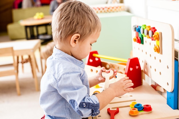 Ein Junge spielt zu Hause mit einem Spielzeug auf dem Tisch