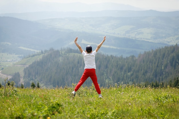 Ein Junge springt auf einen Berg, um sich frei zu fühlen und von der Schönheit, die er sah, frei zu sein