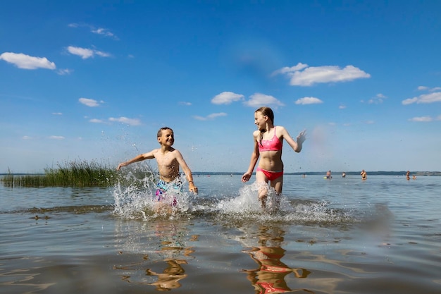 Ein Junge und ein Mädchen spielen im Sommer zusammen auf dem See