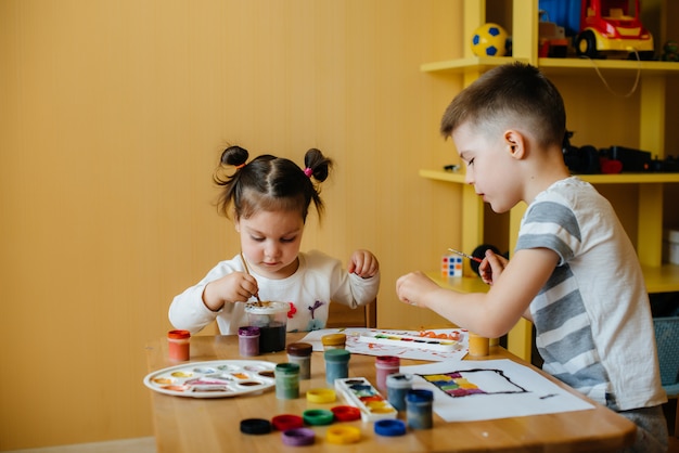 Ein Junge und ein Mädchen spielen zusammen und malen. Erholung und Unterhaltung. Bleib zuhause.