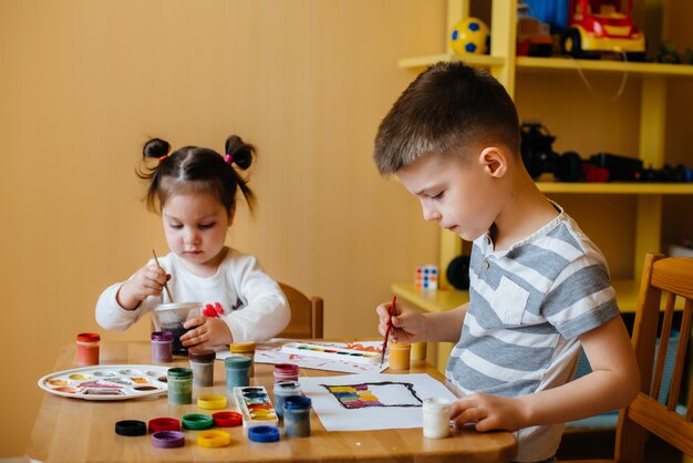 Ein Junge und ein Mädchen spielen zusammen und malen. Erholung und Unterhaltung. Bleib zuhause.