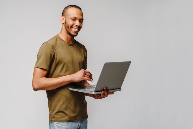 Ein junger Afroamerikaner, der mit einem Laptop PC arbeitet