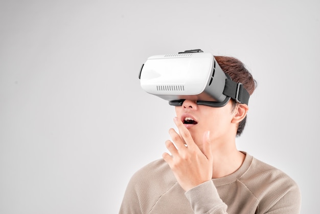 Ein junger asiatischer Mann gestikuliert mit seinen Händen, während er ein VR-Headset verwendet