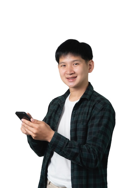 Ein junger asiatischer Mann hält ein Handy in der Hand, er lächelt und ist glücklich, isoliert auf weißem Hintergrund.