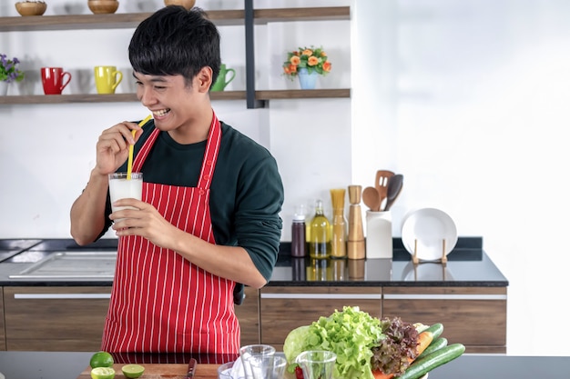 Ein junger asiatischer Mann zeigt Smoothie Limonade.