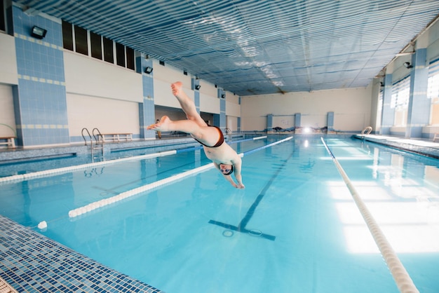 Ein junger Athlet trainiert und bereitet sich auf Schwimmwettkämpfe im Pool vor. Gesunder Lebensstil.