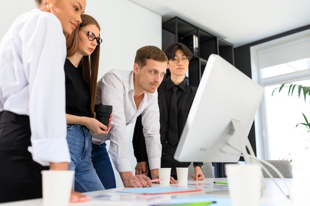 Ein junger Chef schult neue Mitarbeiter im Büro