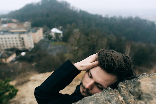 Ein junger christlicher Priester oder Pastor in einem schwarzen Gewand steht auf einem Berg