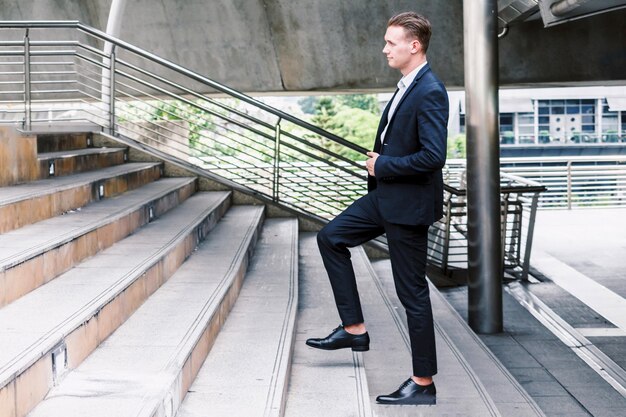 Ein junger Geschäftsmann geht auf der Treppe.