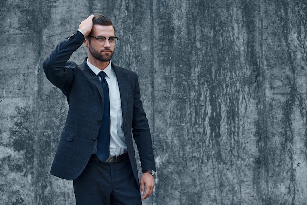 Ein junger Geschäftsmann mit Brille und Bart passt seine Haare an