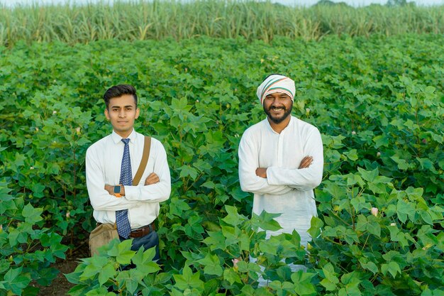 Foto ein junger indischer agronom oder banker zeigt einem landwirt auf dem landwirtschaftsfeld einige informationen