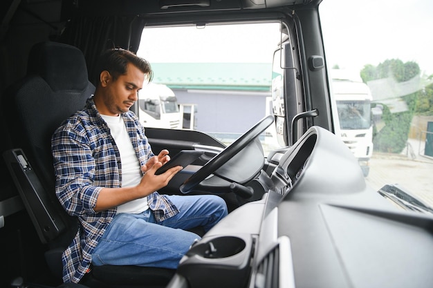 Ein junger indischer Lkw-Fahrer sitzt am Steuer