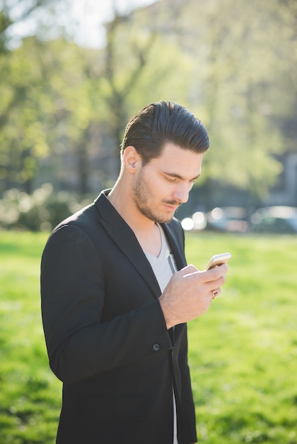 Ein junger italienischer Junge, der einen Smartphone verwendet