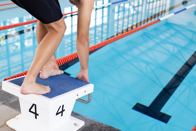 Foto ein junger kaukasischer männlicher schwimmer bereitet sich darauf vor, in einen indoor-pool zu tauchen