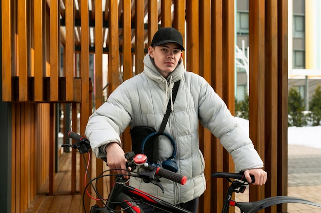 Ein junger kaukasischer Mann mit grauer Jacke und schwarzer Mütze mietete ein Fahrrad