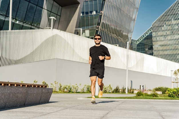 Ein junger männlicher Fitnesstrainer in bequemer Outdoor-Sportbekleidung. Läufer beim aktiven Intervalltraining